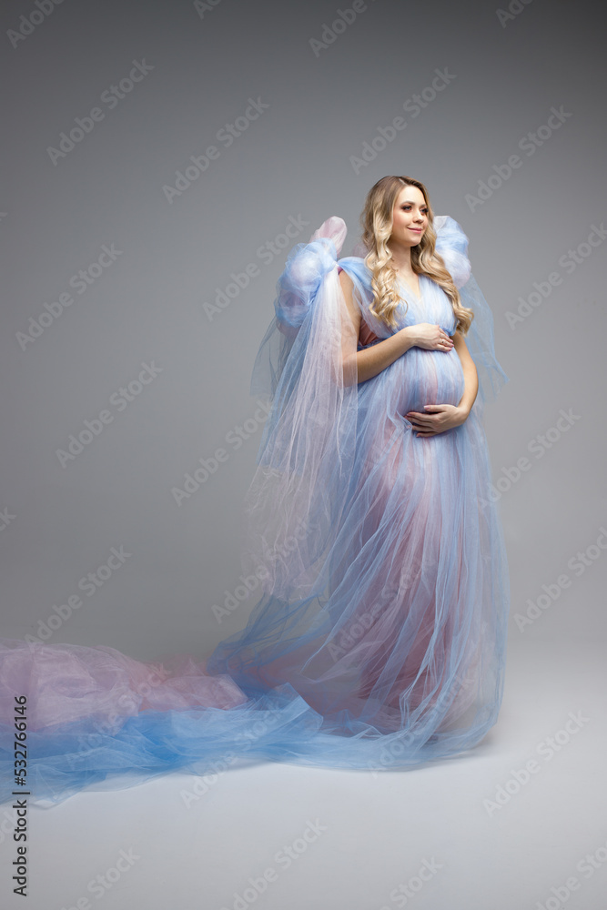 Pregnancy woman with blond hair in blue dress. A young pregancy woman in blue dress. Maternity style. Vertical photo. Pregnancy woman with blond hair in blue dress. A young pregancy woman in blue dress. Maternity style. Vertical photo.