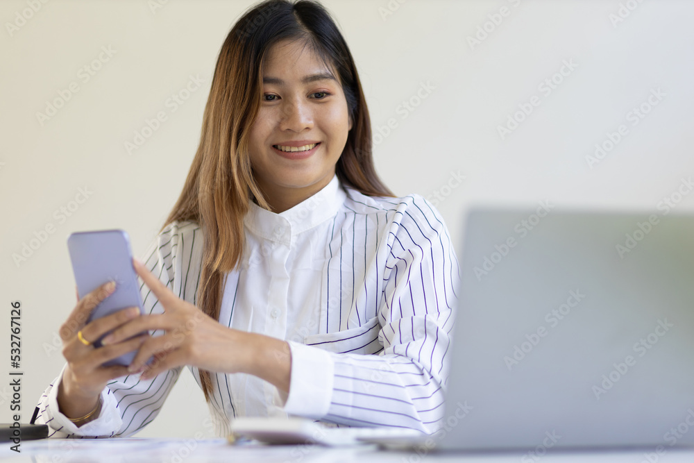 Business woman in office working with laptop talking on mobile phone. Accountant analyzing finances on laptop. Business woman in office working with laptop talking on mobile phone. Accountant analyzing finances on laptop.