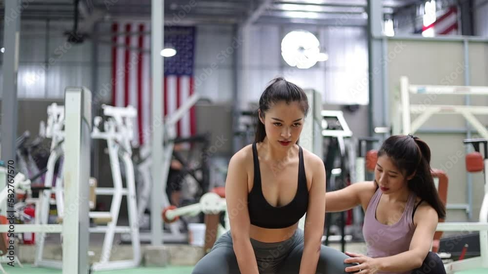 Fitness trainer motivate young active sport woman or athlete exercising using weight lifting machine, sculpt muscles, bodybuilding, lose weight to increase mobility in gym. Fitness trainer motivate young active sport woman or athlete exercising using weight lifting machine, sculpt muscles, bodybuilding, lose weight to increase mobility in gym.