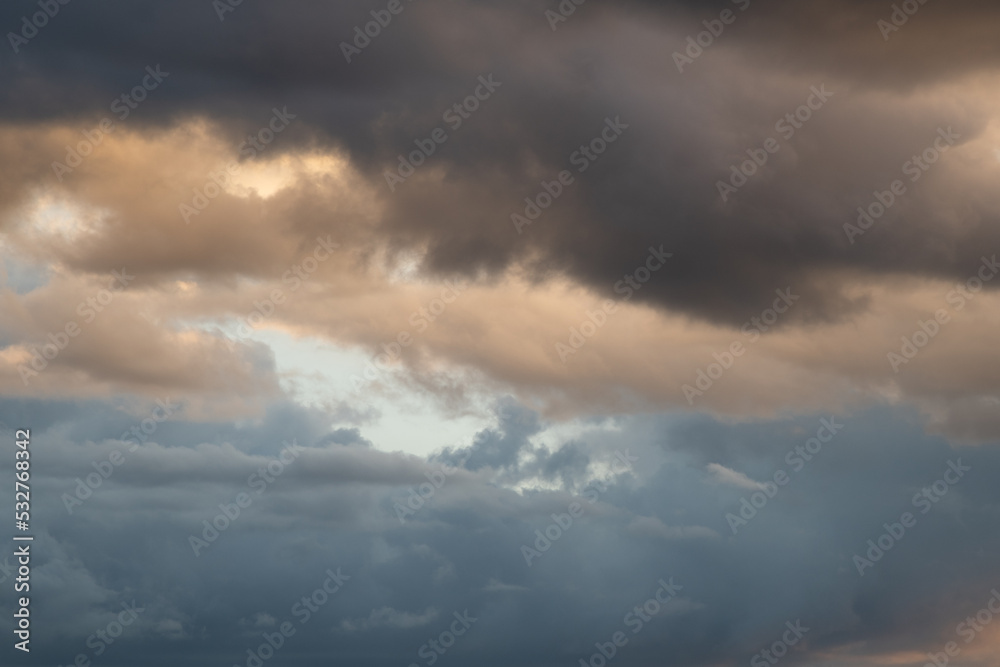 Stormy sky with dramatic clouds from approaching thunderstorms at sunset. Horizontally.