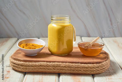 Traditional indian drink turmeric curcuma golden milk with ingredients photo