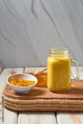 Turmeric latte with milk and honey. Elixir of health and vivacity. Traditional healthy Indian drink. photo