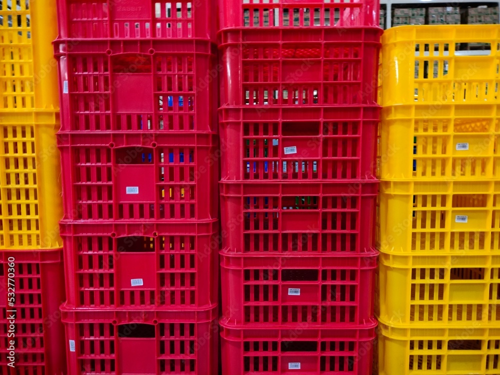 background of a pile of red and yellow plastic baskets background of a pile of red and yellow plastic baskets