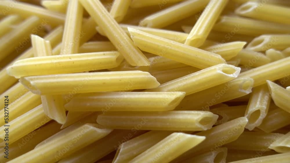 Raw italian penne rigate pasta isolated on wooden background Raw italian penne rigate pasta isolated on wooden background