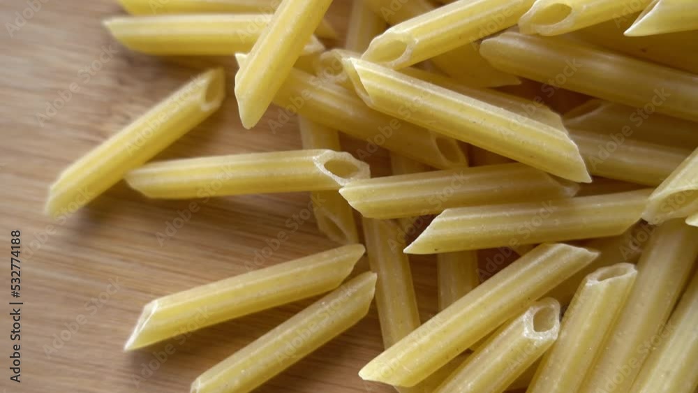 Raw italian penne rigate pasta isolated on wooden background Raw italian penne rigate pasta isolated on wooden background