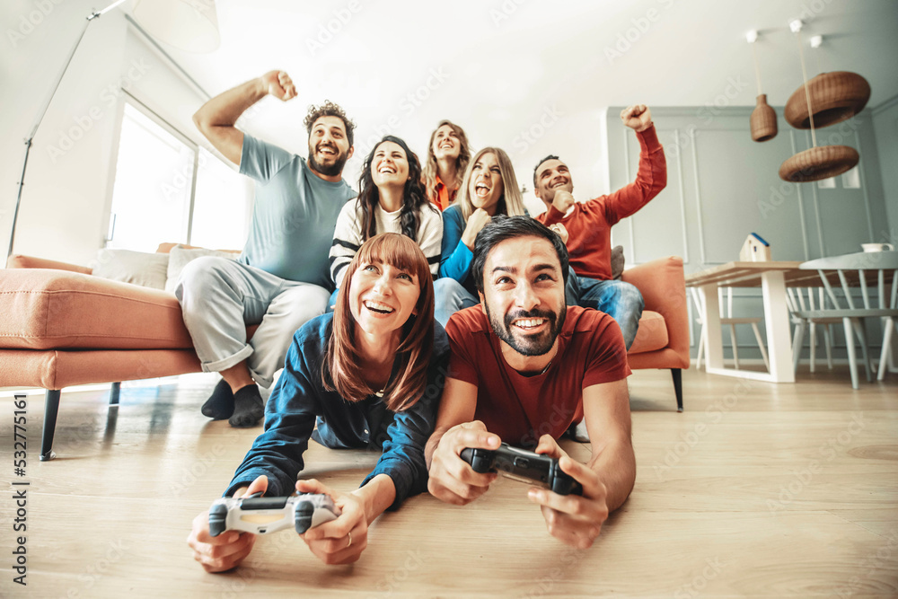 © Davide Angelini - Happy friends playing together video game at home - Group of young people having fun sitting on the couch looking television - Modern technology and friendship concept © Davide Angelini - Happy friends playing together video game at home - Group of young people having fun sitting on the couch looking television - Modern technology and friendship concept