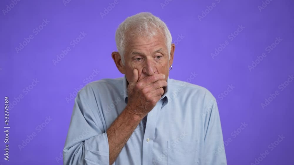 Slow motion portrait of sad upset worried disturb displeased shocked elderly gray-haired man 70s wears blue shirt sigh surprise put hands on face isolated on solid purple background studio Slow motion portrait of sad upset worried disturb displeased shocked elderly gray-haired man 70s wears blue shirt sigh surprise put hands on face isolated on solid purple background studio