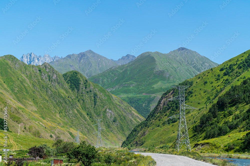 Scenic road and surrounding mountain landscape with forests around view Juta village near Caucasus mountain in Kazbegi, Georgia - Panoramic Landscape of Beautiful Georgian Mountains.