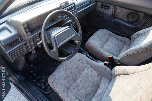 view through the reclined seat with a gray cloth and belt on the front panel of black plastic and the driver's seat in the old car photo