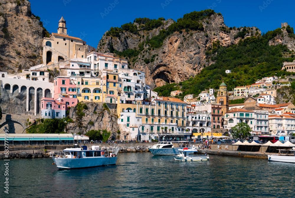 Amalfi harbour on the famous Amalfi Coast in Campania Italy. Picturesque historic village panorama with colorful houses. Summer atmosphere in popular holiday destination seen from a tourist vessel.