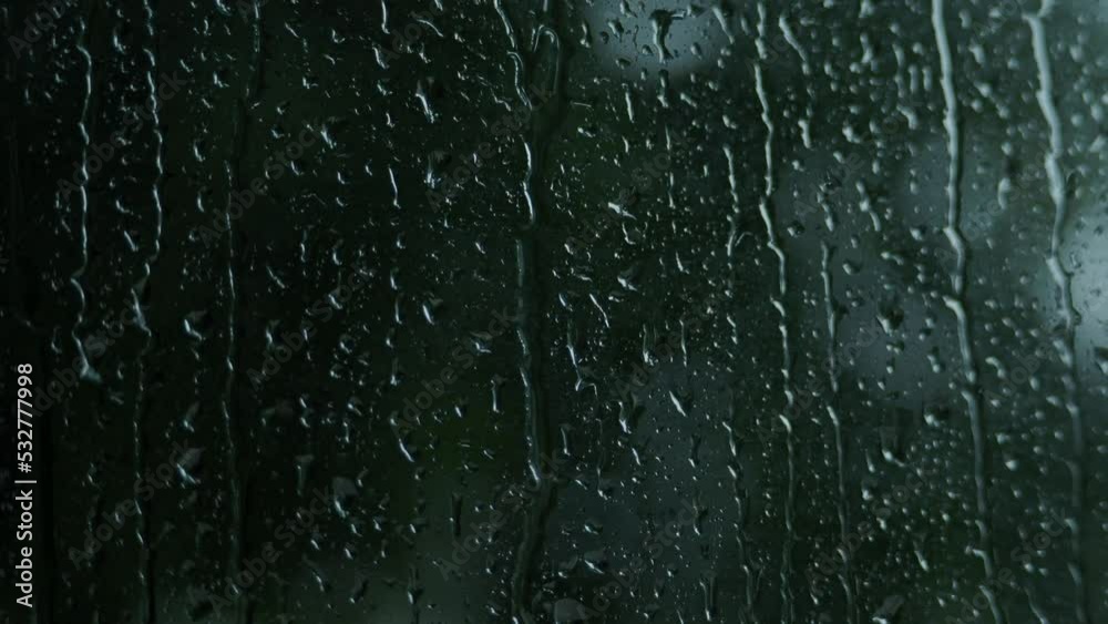 Rain drops on the glass. Small raindrop rests on glass while raining. Background raindrops window. Autumn weather raining season. Blurry dark background. Represent lazy day chill out cafe lover mood. Rain drops on the glass. Small raindrop rests on glass while raining. Background raindrops window. Autumn weather raining season. Blurry dark background. Represent lazy day chill out cafe lover mood.