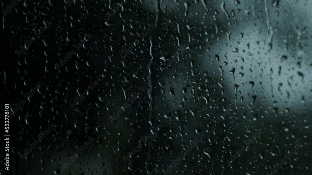 Rain drops on the glass. Small raindrop rests on glass while raining. Background raindrops window. Autumn weather raining season. Blurry dark background. Represent lazy day chill out cafe lover mood. Rain drops on the glass. Small raindrop rests on glass while raining. Background raindrops window. Autumn weather raining season. Blurry dark background. Represent lazy day chill out cafe lover mood.