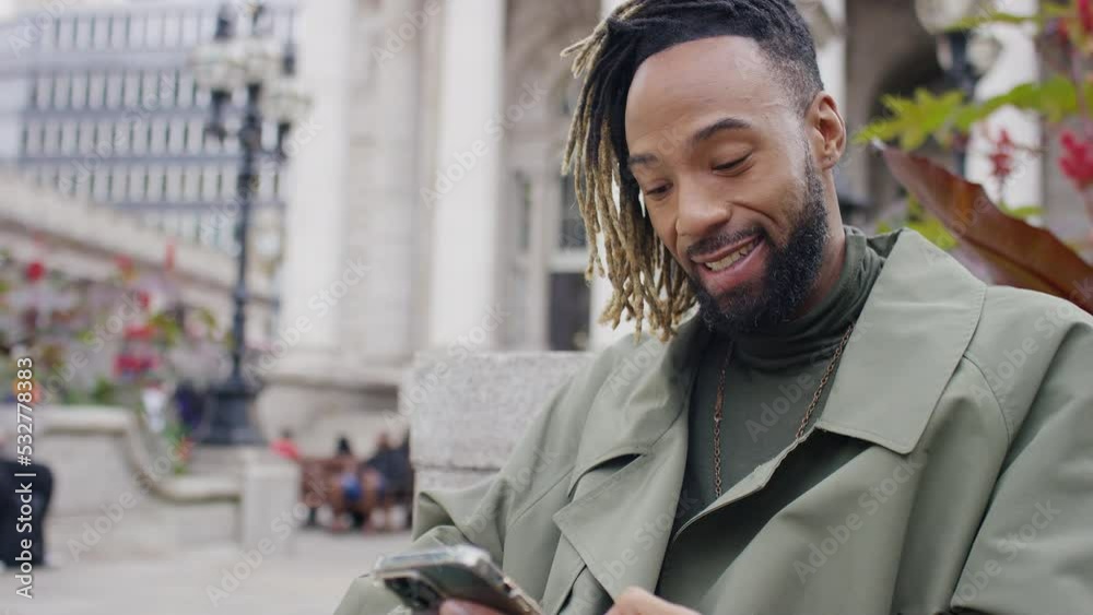 Attractive man using his phone outdoors in the city, in slow motion