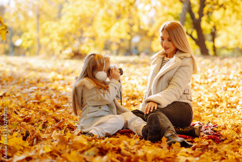 Young Mother and daughter walking in the park and enjoying the beautiful autumn nature. Rest  childhood  walk  family.
