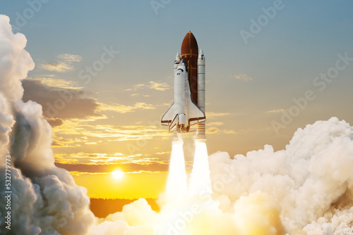 Spaceship lift off. Space shuttle with smoke and blast takes off into space on a background of sunset. Successful start of a space mission. Elements of this image furnished by NASA.