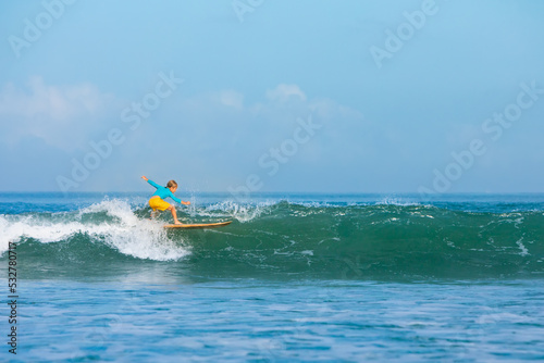 Photography Happy surf boy - young surfer learn to ride on surfboard with fun on sea waves