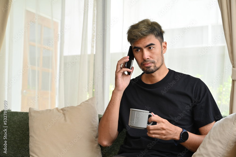 Serious young asian man talking with someone on the phone, Domestic life at home concept. Serious young asian man talking with someone on the phone, Domestic life at home concept.