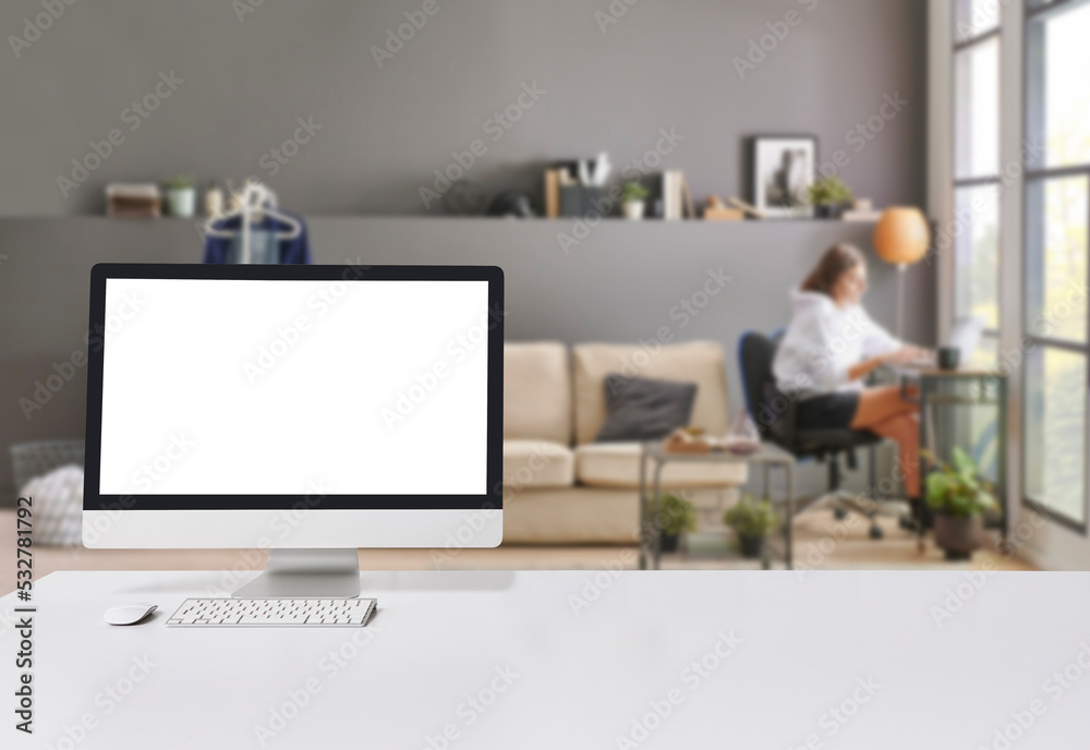 Close up computer screen on the white table style and blue grey living room background. Close up computer screen on the white table style and blue grey living room background.