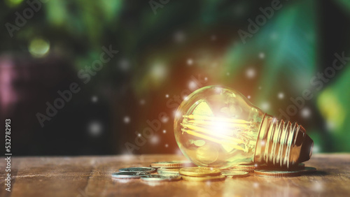 a light bulb on a pile of coins Meaningful in business and finance invitations.