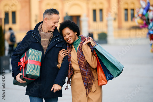Foto Loving couple has fun during Christmas shopping in city.