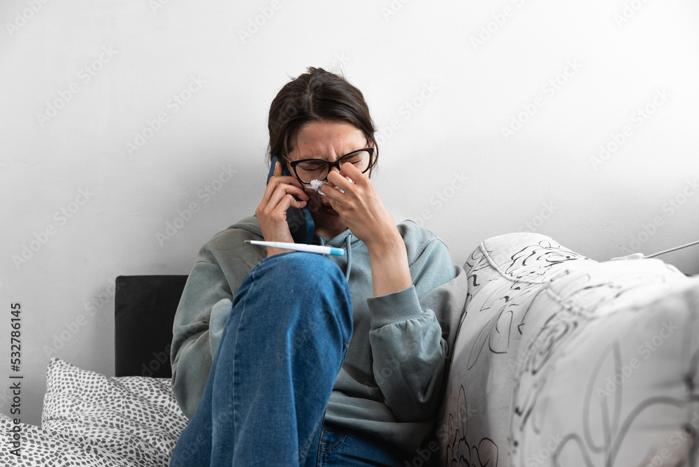 Young business woman calling on smartphone to her work to say that she is sick and she cant go to work. Frustrated female feeling ill and have high body temperature talking with her boyfriend. - obrazy, fototapety, plakaty 