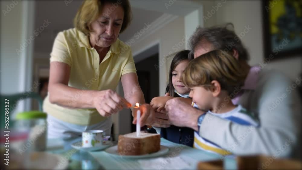 Family celebrating birthday with one candle. grandparents with grandchildren celebrate anniversary Family celebrating birthday with one candle. grandparents with grandchildren celebrate anniversary