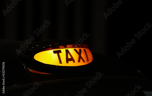 Taxi sign on top of a black cab in London, United Kingdom. Landmark image for England public transportation system. 