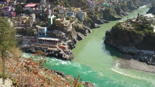 Confluence of muddy colored Alakananda and green colored Bhagirathi river to form Ganges at Devprayag, Uttarakhand, India. This point is known as Sangam and people offers prayers at temple built here. photo