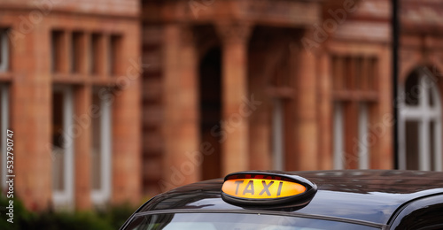 Canvas Print Taxi sign on top of a black cab in London, United Kingdom