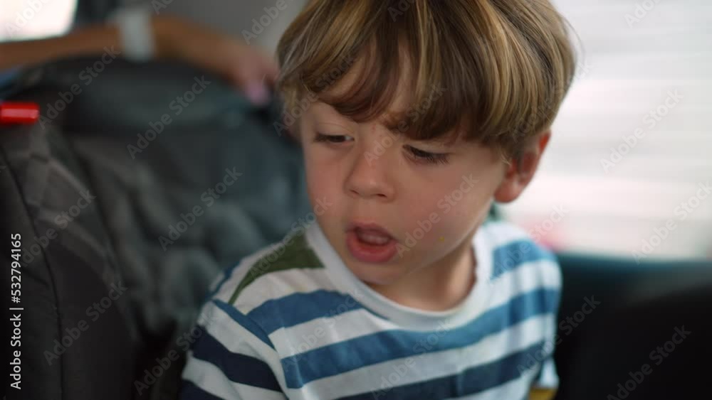 Little boy seated in car backseat traveling on road. Child on security seat inside auto vehicle Little boy seated in car backseat traveling on road. Child on security seat inside auto vehicle