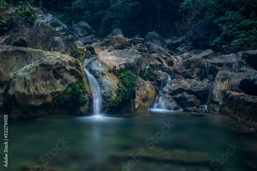 Photo of water flowing between rocks  waterfall in Pudeng village  Aceh  Indonesia.