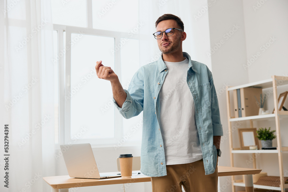 Cheerful happy handsome stylish young businessman in eyewear talk with subordinates staying near office table. Copy space for ad. Remote Job, Technology And Career Profession Concept Cheerful happy handsome stylish young businessman in eyewear talk with subordinates staying near office table. Copy space for ad. Remote Job, Technology And Career Profession Concept