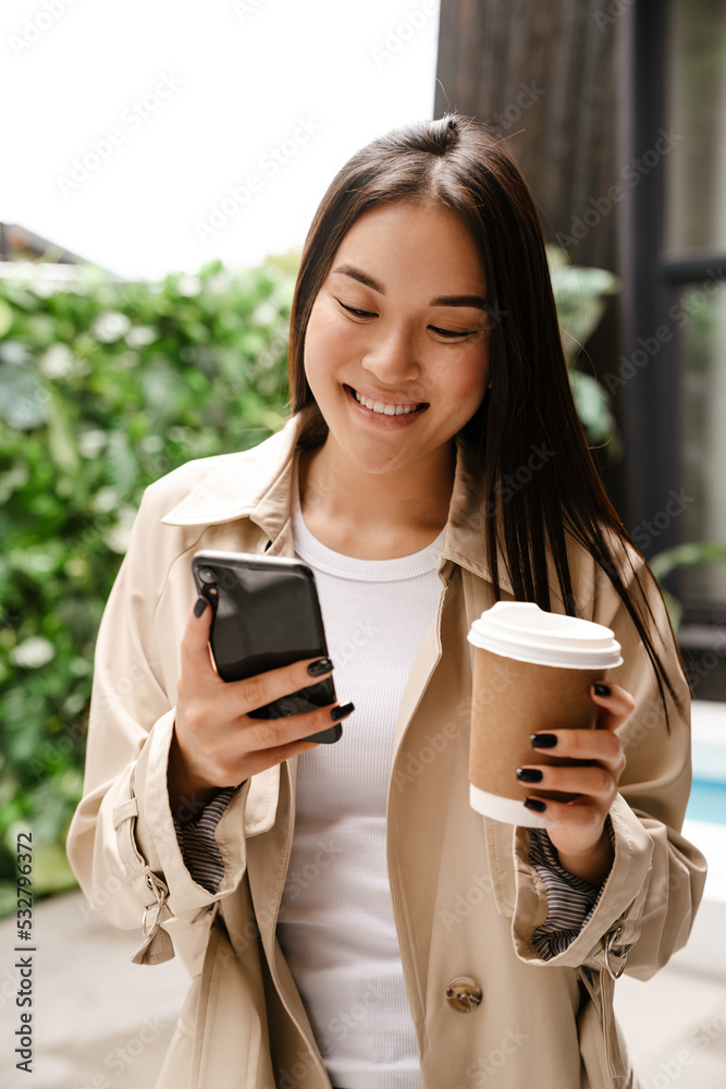 Young asian woman using cellphone while drinking coffee Young asian woman using cellphone while drinking coffee