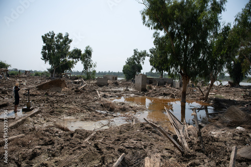 mud-filled village after a natural disaster in Pakistan. Everything is destroyed by floods. Man finds his household items that once were there
