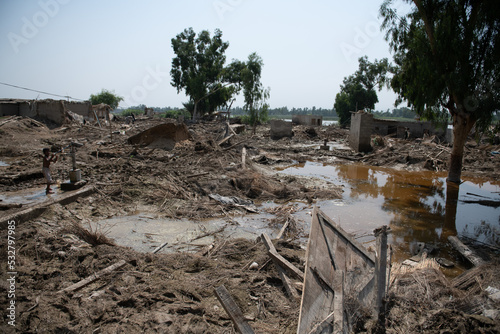 mud-filled village after a natural disaster in Pakistan. Everything is destroyed by floods. Man finds his household items that once were there
