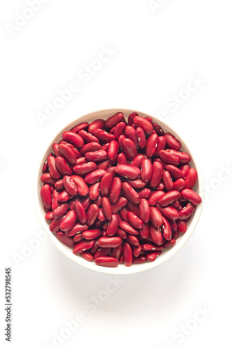 White bowl with red kidney beans on a white background. Top view. Copy space.