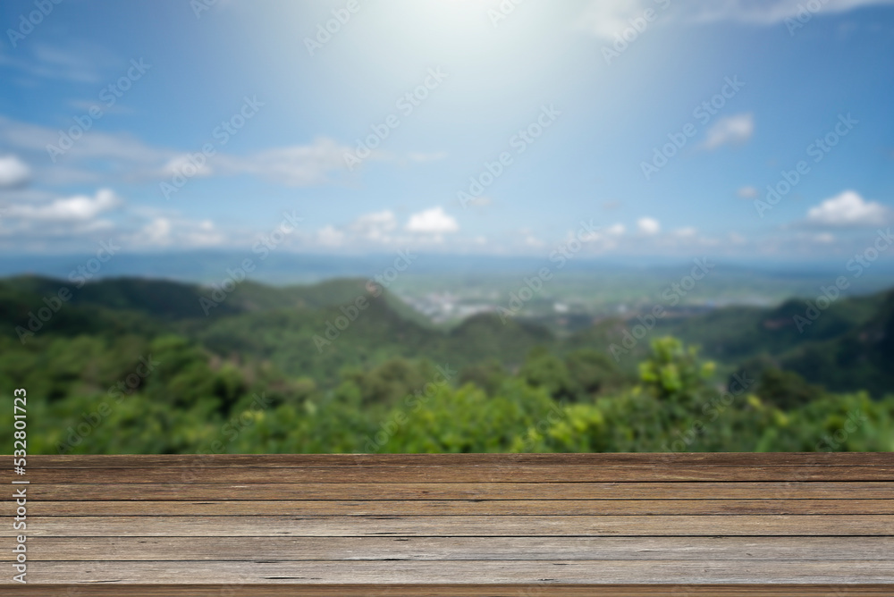 wooden table and beauty blur sky and mountains as background.