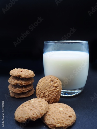 Close up chocolate cookie and white milk with dark background, concept gingerbread, calcium, breakfast, bakery, food, desert