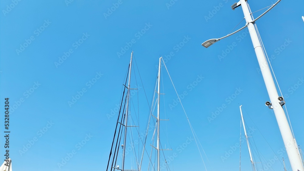 Fototapeta premium Genova, Italy- July 27, 2022:Panorama of the blue sea, light above the water, ocean sunrise. Some little waves in winter days. Clear sky reflected on the water.