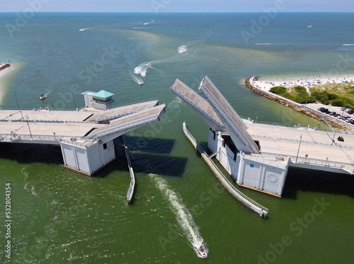 Aerial view of bascule drawbridge opening for boat traffic in Florida with the Gulf of Mexico in the background