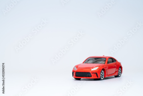 ミニカーの赤いスポーツカー © Haru Works