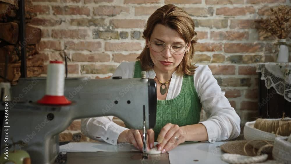Adult woman works with a sewing machine at home. Adult woman works with a sewing machine at home.