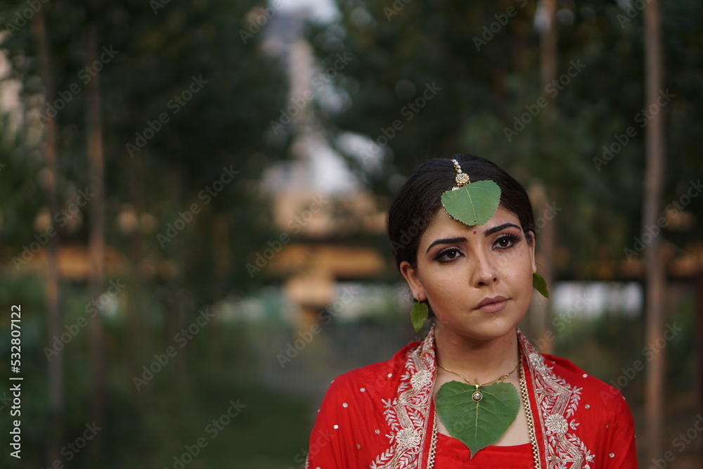 girl wearing red dress covered with green leaf