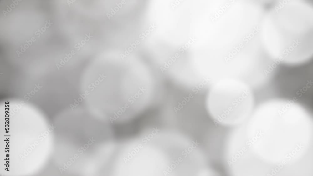 Abstract moving silver and white bokeh lights motion graphics background, 4k looping slow motion animation