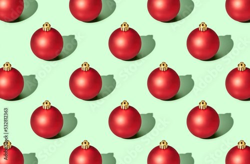Pattern of christmas balls on green pastel background