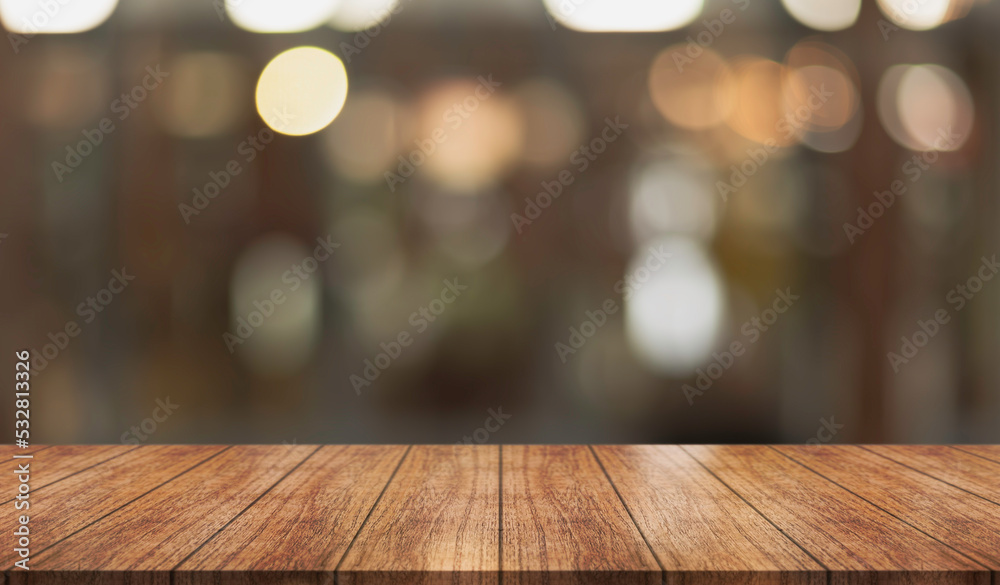 Empty wooden table top with lights bokeh on blur restaurant background.	
