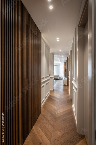 Long corridor with brown wooden wall and parquet floor