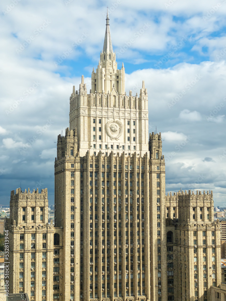 Moscow cityscape within day time. Offices buildings exterior. Building of the Ministry of Foreign Affairs MFA. Rooftops of residential houses on blue sky, bottom up view coat of arms of the USSR Moscow cityscape within day time. Offices buildings exterior. Building of the Ministry of Foreign Affairs MFA. Rooftops of residential houses on blue sky, bottom up view coat of arms of the USSR