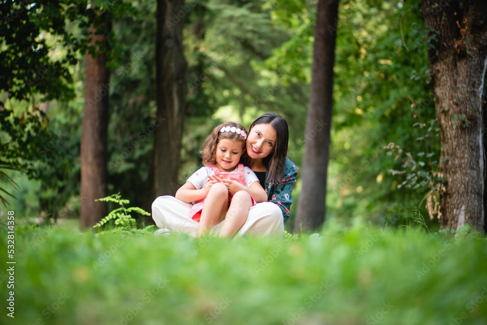 Fototapeta premium mother and daughter sitting in the park hugging each other