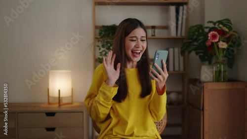  Fooge of happy woman in red sweater is winning and feel exited for something on phone. photo